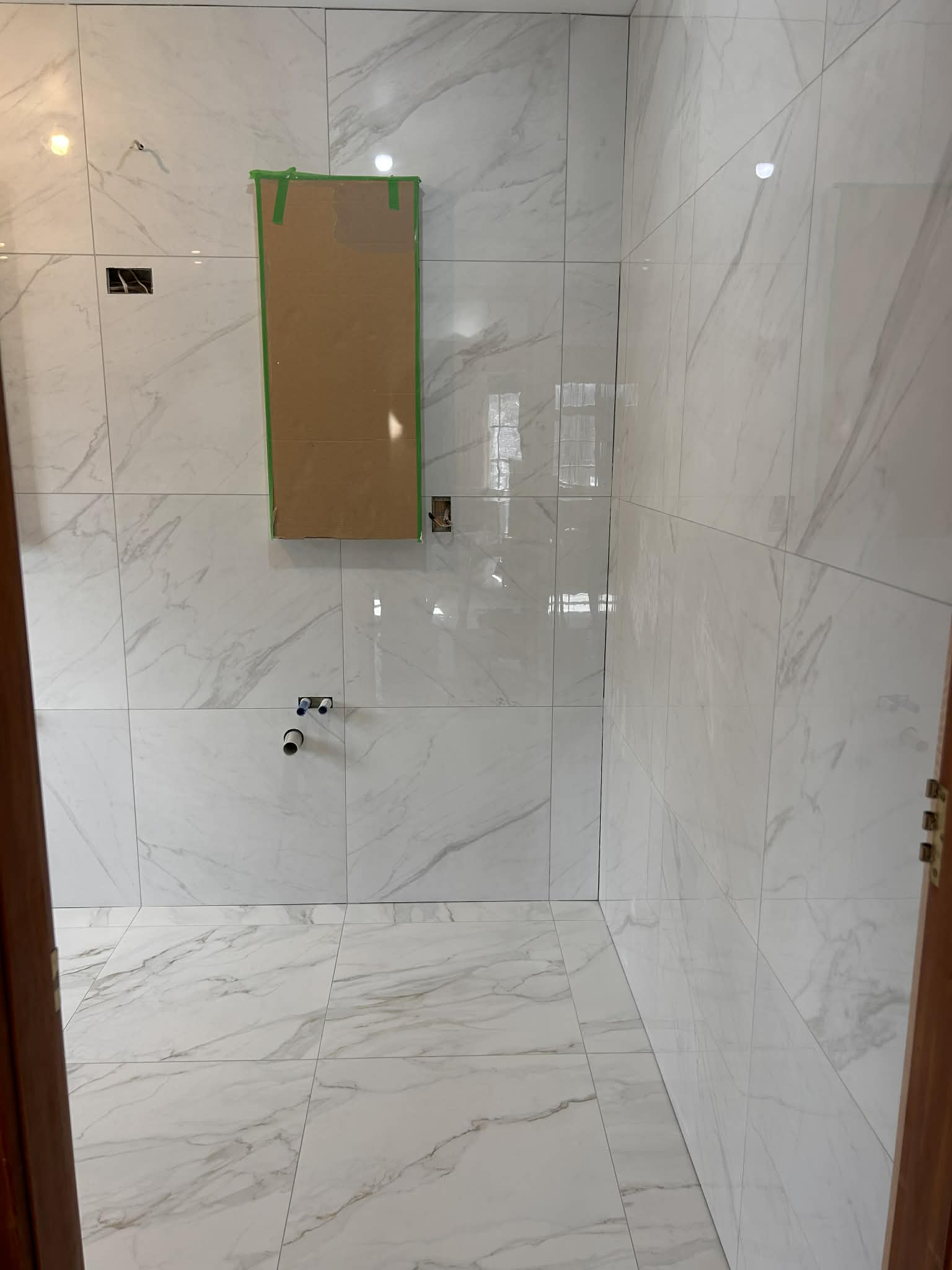 Bathroom renovation with white marble-look porcelain tiles and recessed niche — Wellington tiling project